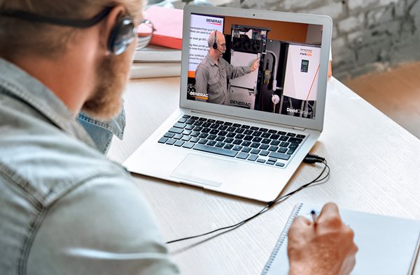 Person watching a training video on the laptop on a desk.